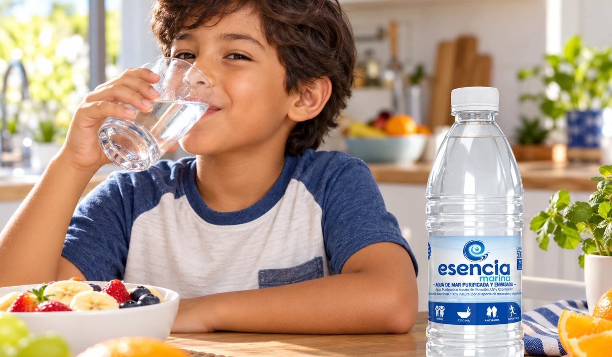 Niño tomando un vaso de agua junto a la botella de 500 ml de Esencia Marina
